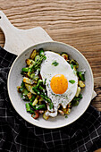 Potatoes, asparagus, and broad beans with fried egg and bacon