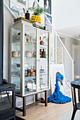 Vitrinenschrank mit Geschirr und kunsthandwerkliche, blaue, skulpturale Sideboard in offenem Wohnraum