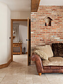 Leather couch in front of rustic brick wall