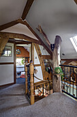 Treppenabsatz mit Baumstamm im Dachgeschoß