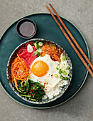 Korean bibimbap bowl with marinated radishes and a fried egg