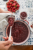 Fill cooked strawberry jam into jars