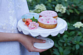 Donuts with pastel icing on pastry stand