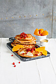 Buckwheat pancakes with clementines, pomegranate seeds and almond cream