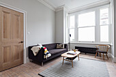 Anthracite sofa and coffee table in room with light grey walls and stucco work