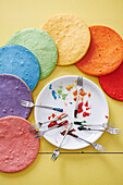 Rainbow colored cake layers with food coloring on plates