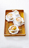 Passion fruit pudding served in tea cups on a tray