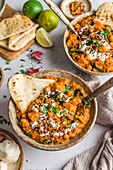 Sweet potato and spinach curry in a bowl with naan bread