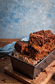 Parkin cake sliced into squares and piled up in a tin