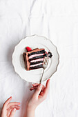 Raspberry and chocolate cake slice, on plate with fork