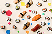 Verschiedene Sushi dekoriert mit bunten Punkten auf hellem Untergrund