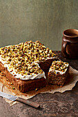 Carrot cake with cream cheese frosting and caramelized pistachios