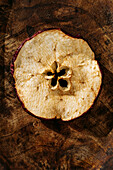Close up of a thin slices of dried apple fruit, on a wooden table