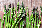 Asparagus spears on a textured wooden background