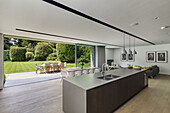 Kitchen island and dining area with classic chairs in front of open patio door