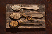 Full wooden spoons with set of rice and sesame seeds with barley grains
