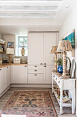 Table lamps with carved base on console in white cottage kitchen