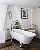 Freestanding bath in loft bathroom with repurposed paneling on the wall