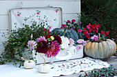 Alter Koffer gefüllt mit Blumen und Kürbis dekoriert