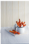 Thin carrot fries in an enamel cup