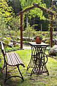 Inviting seating area with table made from old sewing machine in a garden