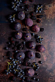 Herbstfrüchte (Feigen, Brombeeren, Weintrauben) auf dunklem Metalluntergrund
