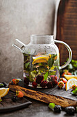 Tea with fresh berries in a glass pot