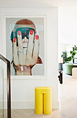 Modern art on the wall including yellow designer stool