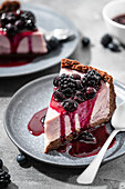 A slice of blueberry cheesecake with berry sauce