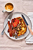 Egg bread with crispy bacon, mushrooms, and baked tomatoes