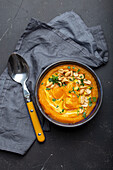 Ceramic bowl with pumpkin cream soup decorated with peanuts