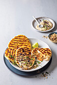 Braaibroodtjies - grilled flatbreads with melted butter and hummus (South African grilled cheese)