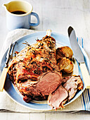 Roasted leg of lamb with roasted onions and rosemary, served with sauce