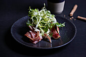 Parma ham with fig and mozzarella, topped with salad garnish