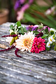 Bunte Dahlien auf Holztisch (Dahlia), Blumenkranz binden
