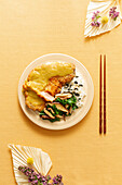 Top view of tasty katsu curry with fried chicken and sauce served with rice and mushroom on yellow background with chopsticks