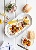 Top view of feta dip with roasted cherry tomatoes on a white wooden table