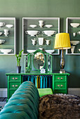 Custom-made glass cabinets with vase collection mounted on a green wall