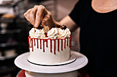 Dripping Cake mit Sahnetupfen und Schokokugeln verzieren