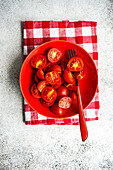 Summer salad of ripe red cherry tomatoes in the bowl on concrete background