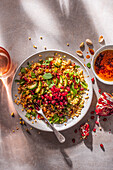 Giant couscous salad with smoked chilli harissa oil and pomegranate seeds