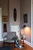 Alter Stuhl mit neuem Bezug in Zimmerecke, Kunstwerke an der Wand