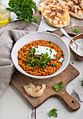 Vegan Red Lentil Dal with Herbal Coconut Cream and Naan Bread (India)