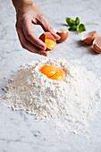 Eggs being added to flour (pasta dough)