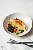 Turnip and pea strudel on black beans in sesame stock