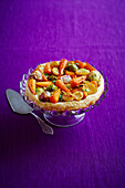 Puff pastry vegetable pie on pastry stand and purple background