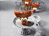 Funny moose cookie with caramel on a metal dessert stand