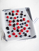Berries laid out on baking paper to freeze