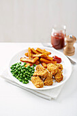 Salmon nuggets with sweet potato fries and peas