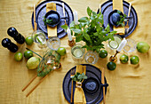 Gedeckter Tisch in Gold und Blau, mit Minze und Limetten